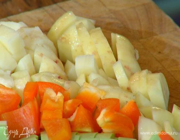 Картофель почистить, порезать маленькими кубиками, выложить в сковороду с луком и чесноком, все слегка посолить.