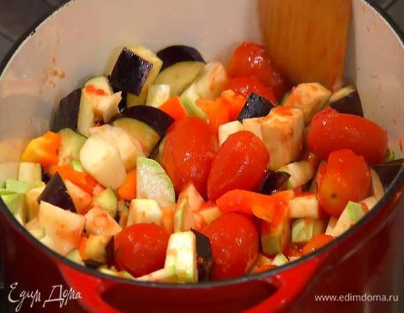 Помидоры в собственном соку выложить в кастрюлю с овощами, все перемешать, накрыть крышкой и тушить на небольшом огне минут 30 до готовности.