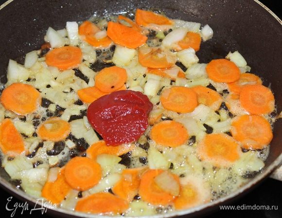 Мясо отложить в тарелочку, а в этом же масле слегка обжарить мелко нарезанный лук и морковь кружочками, затем добавить томатную пасту (мне нравится томатная паста «Помидорка»).
