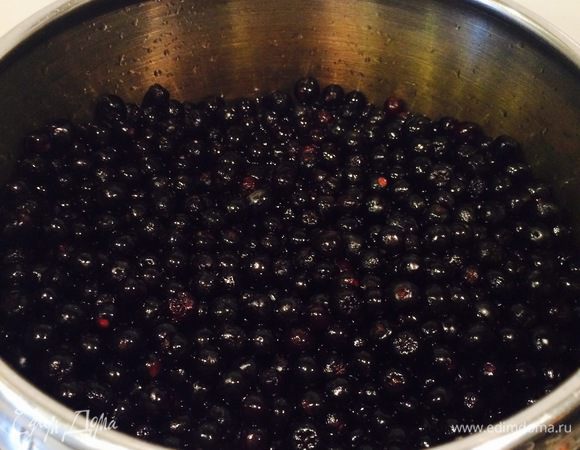 Стакан воды (можно чуть больше) выливаем в кастрюлю, где будем варить варенье. Воду доводим до кипения, снимаем с плиты. В кипяток высыпаем наши ягодки. Аккуратненько перемешиваем деревянной ложечкой, чтобы каждая из ягодок побывала в воде. Это мы делаем для того, чтобы рябина стала мягкой и лучше пропускала сироп. Проделываем это 5-7 минут. 