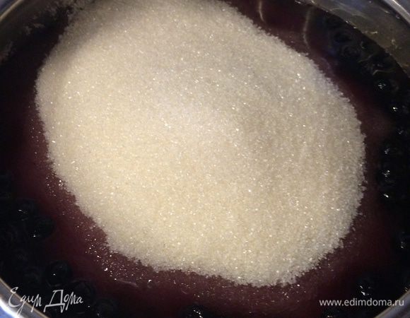 Возвращаем кастрюлю с ягодами на плиту, включаем огонь чуть больше среднего. Добавляем весь сахар, растворяем его, аккуратно помешивая. Доводим до кипения. Делаем огонь меньше среднего и варим 15 минут.