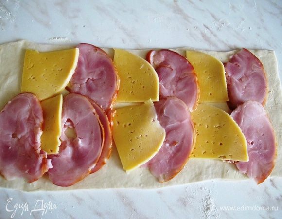 На пласт теста выкладываем ветчину и сыр.