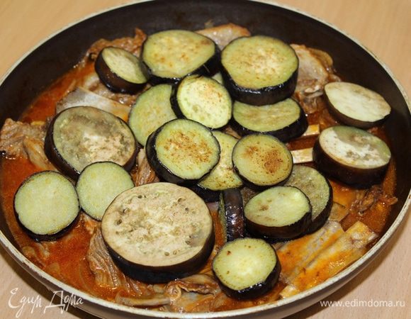 Когда мясо станет мягким, добавить баклажаны, предварительно обжаренные в другой сковороде. Аккуратно все перемешать, чтобы кружочки баклажан остались целыми. Потомить на медленном огне 5 минут. Выключить плиту, дать настояться 5 минут. На гарнир можно подать рис. 