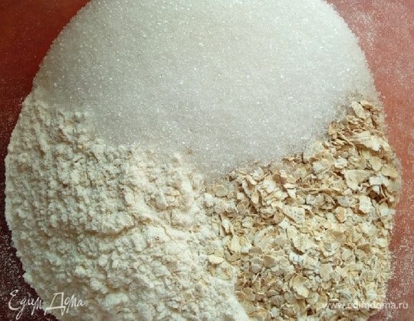 Перемешать в миске муку, хлопья, сахар и разрыхлитель (чайная ложка без горки, разрыхлитель делаю сама, смешивая соду, лимонную кислоту и муку). Овсяные хлопья должны быть мягкого сорта, чтобы выпечка не получилась жесткой. Сахара можно положить и побольше, если вы любите послаще, я стараюсь делать выпечку менее сладкой.