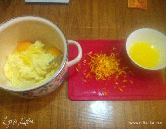 Трем на терке цедру из половины апельсина. Выжимаем из мякоти апельсина 50 — 60 мл сока. В чашке растираем масло с сахаром, добавляем яйца и ваниль. Массу хорошо перемешиваем.