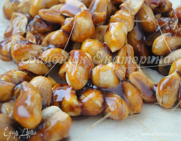 Выкладываем карамелизированный арахис на хорошо промасленную пекарскую бумагу и даем остыть.