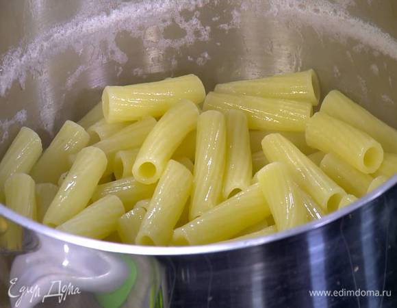 Ригатони отваривать в подсоленной воде на 1‒2 минуты меньше, чем указано на упаковке, затем воду слить и сохранить, а макароны вернуть в кастрюлю.