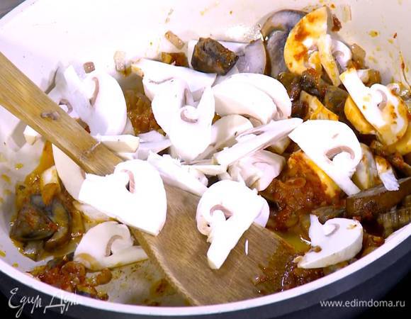 Лесные грибы и шампиньоны нарезать тонкими пластинками, выложить в сковороду с луком и чесноком, все посолить и перемешать.