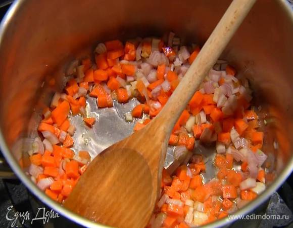 Разогреть в большой кастрюле оливковое масло и немного обжарить подготовленные овощи.