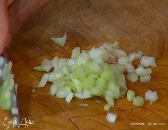 Сельдерей мелко порезать, добавить в кастрюлю и обжаривать, пока лук не станет слегка прозрачным.