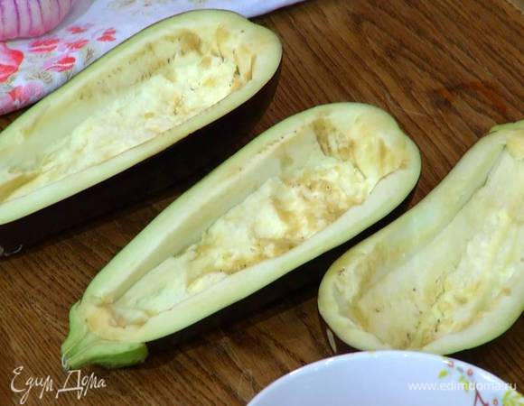 Баклажаны вместе с плодоножкой разрезать вдоль пополам и вырезать мякоть, стараясь не прорезать стенки.