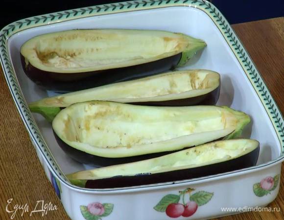 Лодочки из баклажанов выложить в жаропрочную керамическую форму срезами вверх, сбрызнуть оливковым маслом и запекать в разогретой духовке 10‒15 минут.