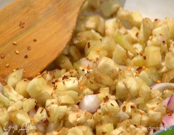 Разогреть в сковороде 2‒3 ст. ложки оливкового масла, выложить нарезанные баклажаны и лук, посыпать солью и перцем чили, перемешать и обжарить до полуготовности.