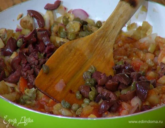 В сковороду с овощами добавить оливки, каперсы, измельченный тархун и все перемешать.