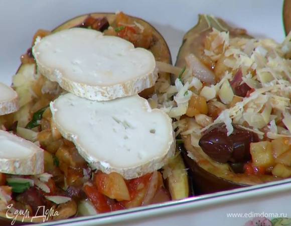 На подпеченные баклажаны выложить овощную начинку, посыпать натертым пармезаном, сверху поместить ломтики козьего сыра.