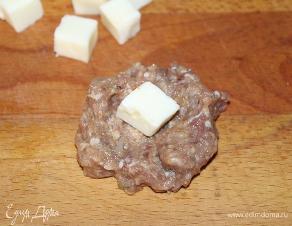 Сыр нарезать небольшими кусочками, выложить на кусочки фарша.