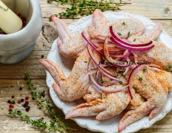 Крылышки хорошо промыть и обсушить. Лук нарезать полукольцами или соломкой, оборвать листики с тимьяна. Соединить крылья, лук, специи, хорошо перемешать и оставить на 2 — 3 часа.