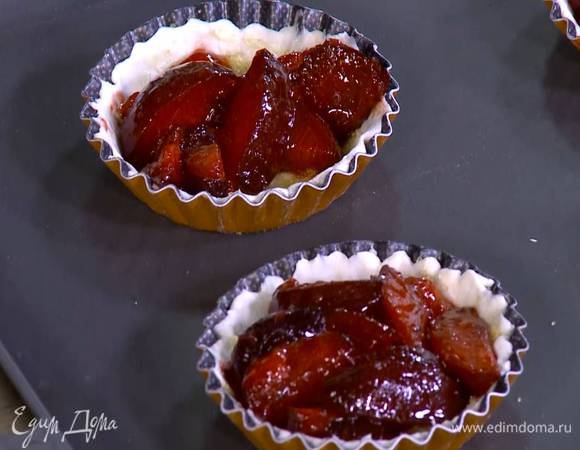 Смазать тесто в формочках предварительно размягченным сливочным маслом, присыпать оставшимся сахаром и разложить сливы со специями.