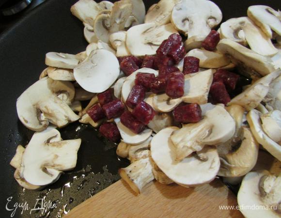  На растительном масле (2 ст. л.) слегка обжарить грибы и колбаски.