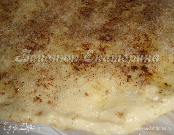 Делим тесто на две части. Так удобнее работать. 
Формируем прямоугольный пласт.
Промазываем его сливочным маслом.
Посыпаем сахаром и корицей.