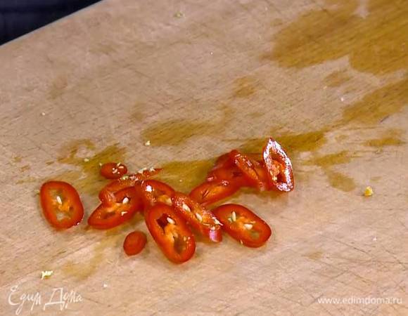 Перец чили вместе с семенами нарезать тонкими колечками.