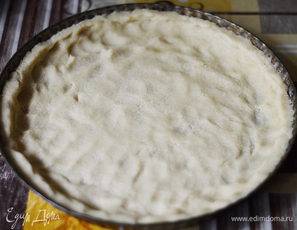 Смазать форму для выпечки сливочным маслом и распределить тесто по форме, сформировав аккуратные бортики.