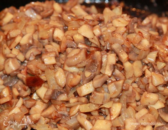 Лук чистим и режем мелким кубиком, обжариваем на растительном масле. Грибы тоже моем, обсушиваем, нарезаем мелким кубиком, добавляем к луку и обжариваем на сильном огне, помешивая, минут 5 — 7. Обжаривать на сильном огне нужно для того, чтобы шампиньоны не пустили сок, не потемнели и были тверденькими после обжарки.