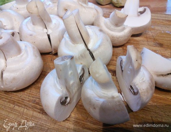 Помыть и обсушить шампиньоны, нарезать на половинки, мелкие грибы оставить целиком.