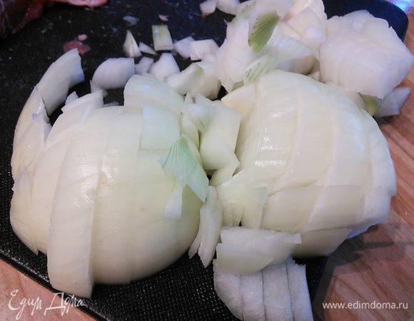 За время жарки мяса порубить крупным кубиком лук. Очистить чеснок. 