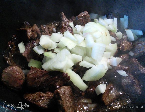 Вернуть в кастрюлю мясо, добавить лук и чеснок, обжарить вместе с мясом в течении 2-4 мин. 