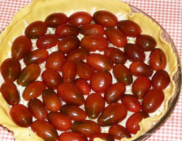 Помидоры разрезать пополам, выложить на пирог срезом вниз.