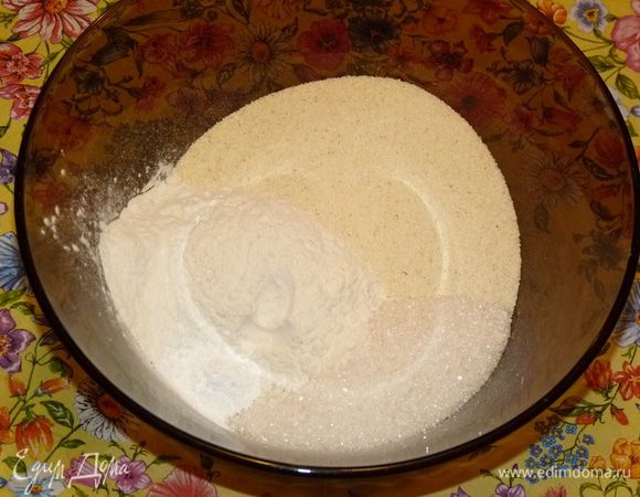 Смешать муку, сахар, манную крупу, 1 ч. л. разрыхлителя и 1 ч. л. корицы. Один стакан уже готовой смеси всыпать в форму и разровнять.