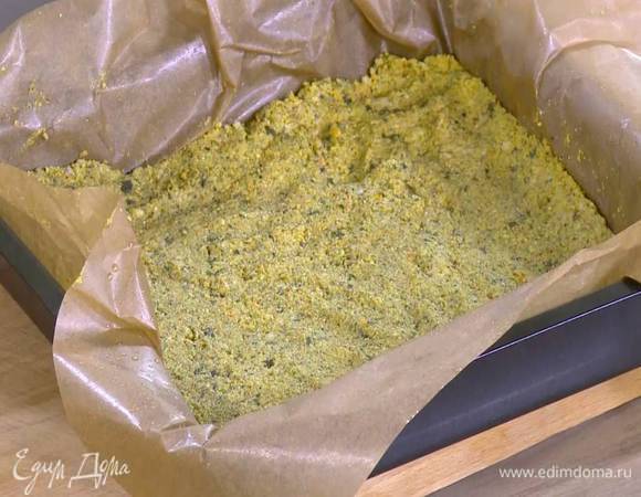 Противень выстелить бумагой для выпечки, смазанной оливковым маслом, равномерно выложить морковную массу и уплотнить ее руками.