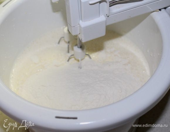 Добавить творожный сыр, растительное масло и йогурт. Перемешать. Просеять муку с разрыхлителем.
