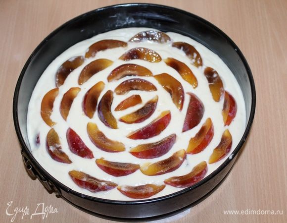 Выложить тесто в форму  диаметром 28 см. Остальные сливы нарезать дольками и уложить в виде лепестков.