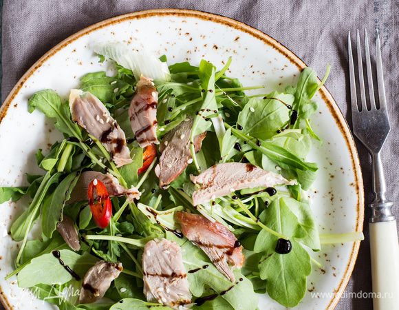 На тарелки выложите руколу, кресс-салат и шпинат, сбрызните соусом, затем выложите ломтики утиной грудки, посыпьте сверху кунжутом. Украсьте салат бальзамическим соусом и подавайте. Приятного аппетита!