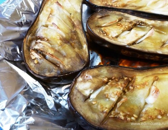 Баклажаны разрезать вдоль, сделать неглубокие насечки и вставить в них пластинки чеснока. Старайтесь не прорезать баклажаны насквозь. Посолить, поперчить, сбрызнуть чесночным маслом Biolio. Запечь до мягкости в духовке. 
Аккуратно ложкой вынуть готовую баклажано-чесночную мякоть, порубить ее и смешать с начинкой. Брынзу размять вилкой и подмешать к начинке.