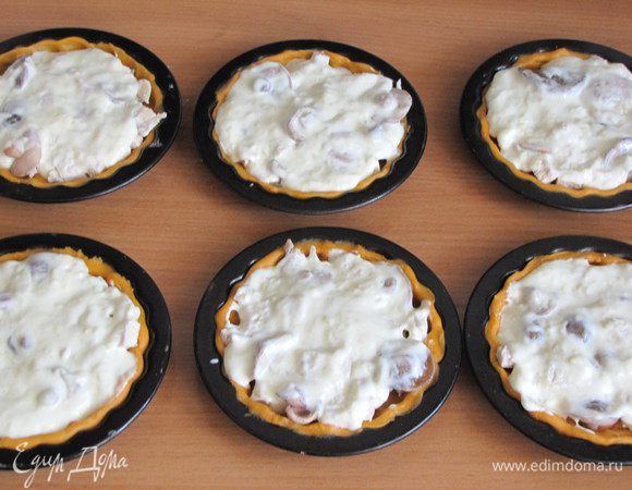 Сверху залить сырным соусом, равномерно распределить его. На одну тарталетку идет примерно 1,5 ст. л. сырного соуса.