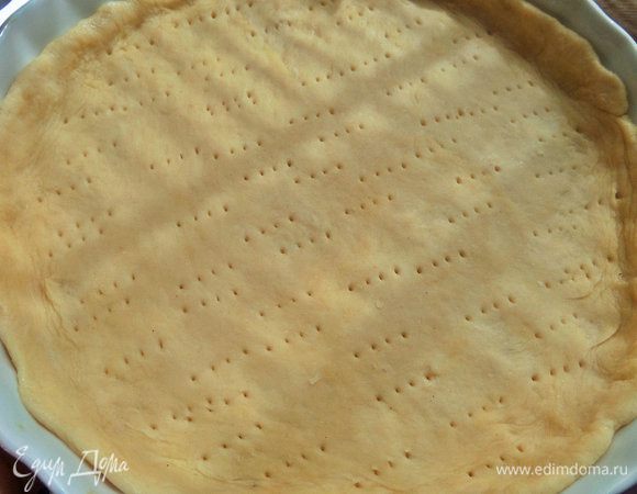 Пласт сложить пополам и перенести в форму, сделать бортики, наколоть дно вилкой.