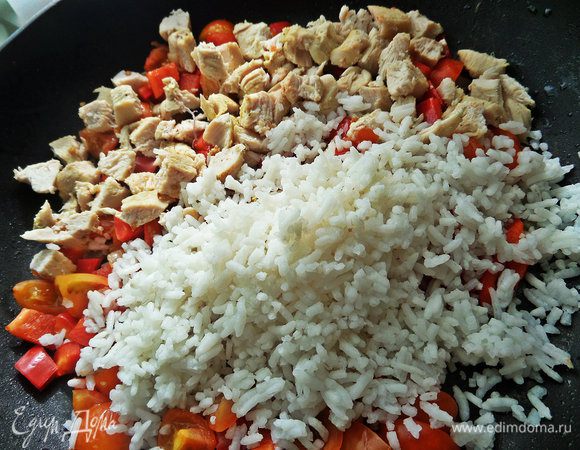 Высыпать из пакетика в сковороду готовый рис и курицу.