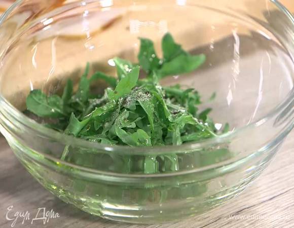 Руколу выложить в глубокую посуду, сбрызнуть уксусом, оставшимся оливковым маслом, посолить, поперчить и перемешать.