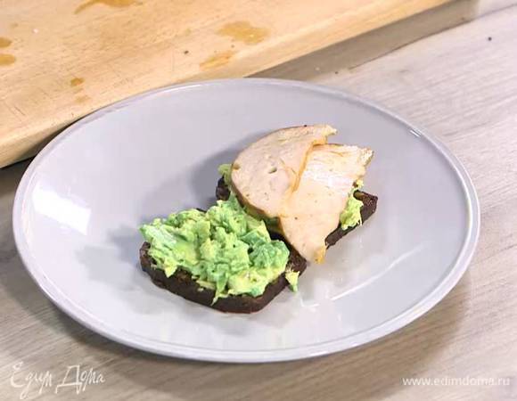 Хлеб прогреть на той же сковороде, где жарилась ветчина с помидорами, затем смазать горчицей, выложить на него размятый авокадо и ветчину.