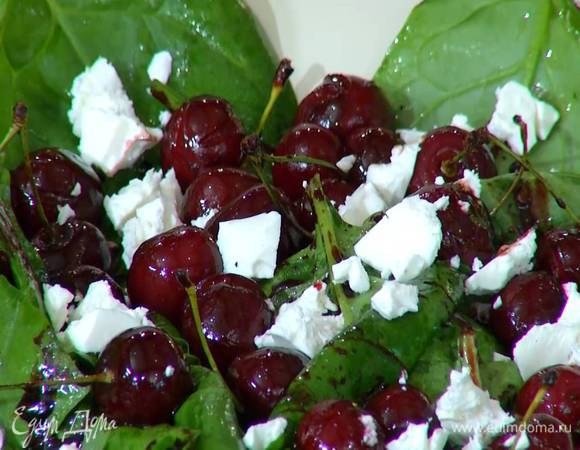 Шпинат полить заправкой, перемешать и выложить на блюдо, сверху разложить вишню и измельченную руками фету.