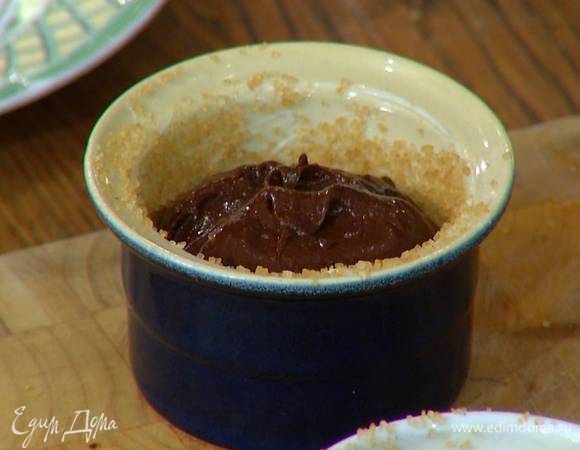 Небольшие керамические формы смазать внутри оставшимся сливочным маслом, посыпать коричневым сахаром и разложить шоколадную массу, заполняя их на 2/3 объема.