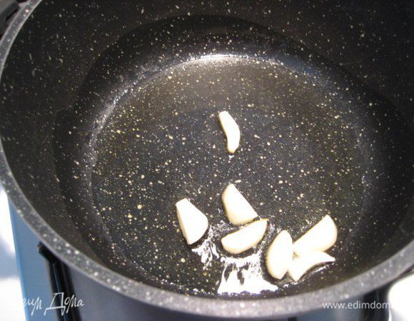 В глубоком сотейнике разогреть оливковое масло, добавить крупно нарезанный чеснок, обжарить, затем чеснок выбросить.