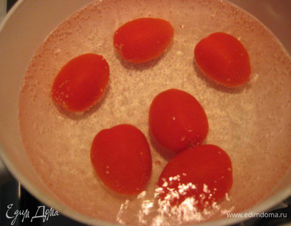 На помидорах (у меня некрупные помидоры) сделать крестообразные надрезы, бланшировать в кипящей воде 2 минуты, снять кожицу, мелко нарезать, высыпать в сотейник, потушить на слабом огне 5 минут.