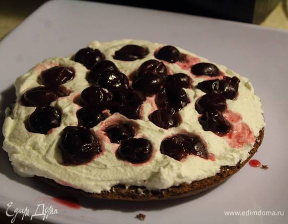 Бисквит из формы разрезать пополам. Одну половинку уложить основой, намазать кремом и выложить черешни.