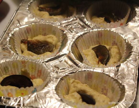 В формочки для маффинов положить тесто на половину, внутрь положить кусочек сливы (можно и черешню, или малину или других ягодок).