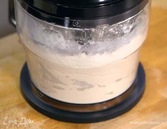 В чаше комбайна соединить нарезанное масло, муку с разрыхлителем и измельчить все в крошку, затем влить 125 мл молока и все взбить.