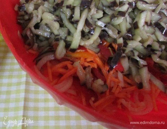 Обжаренные баклажаны вместе с растительным маслом вылить в подготовленные овощи. Аккуратно перемешать. Накрыть крышкой и дать остыть. Несколько раз перемешать за время остывания.